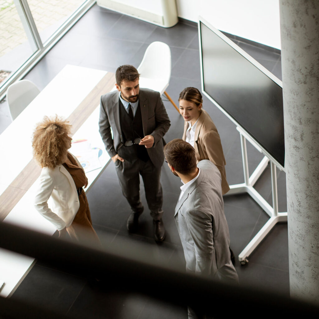 Gruppe von Führungskräften im Gespräch auf einer Treppe